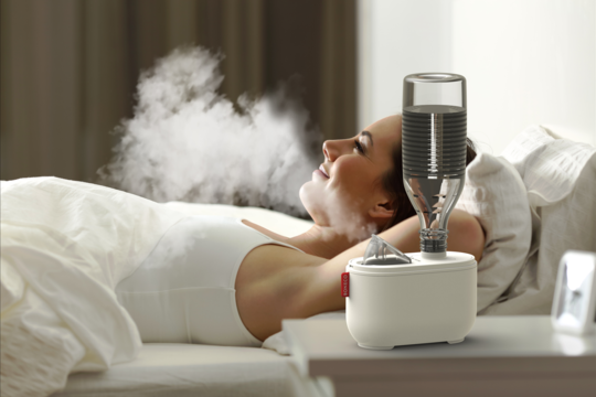 U100 ultrasonic travel humidifier BONECO woman relaxing in bed without light